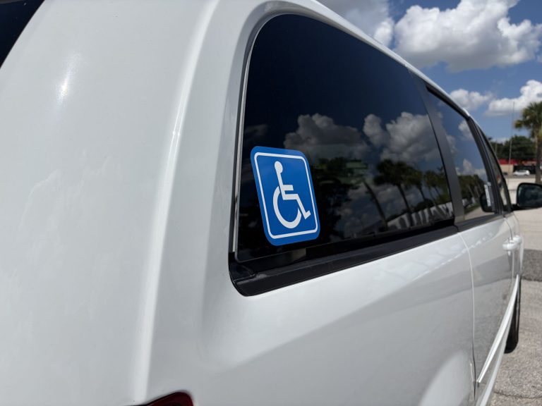 Blue International Symbol of Access decal on the rear quarter window of the van