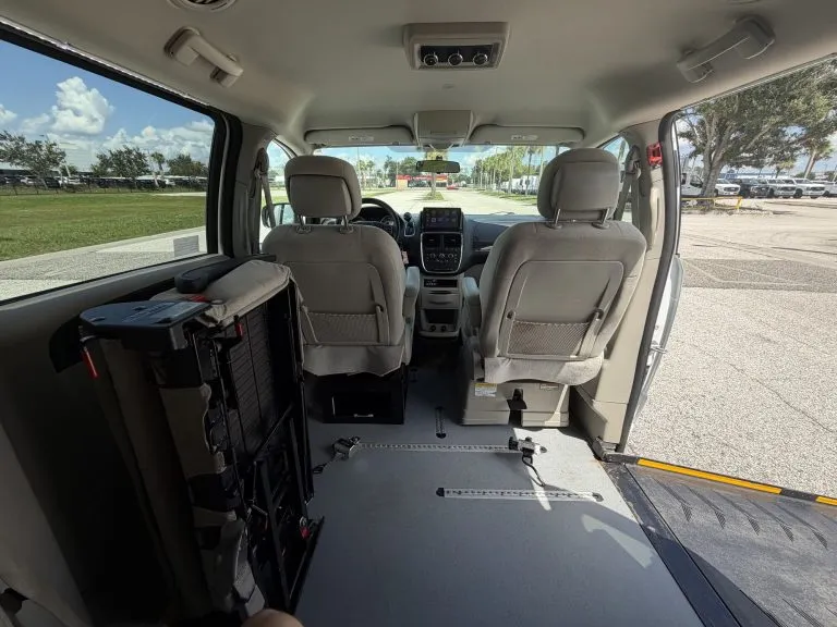 Van interior looking forward from the rear seat, showing the open wheelchair floor space between the front seats and the side door