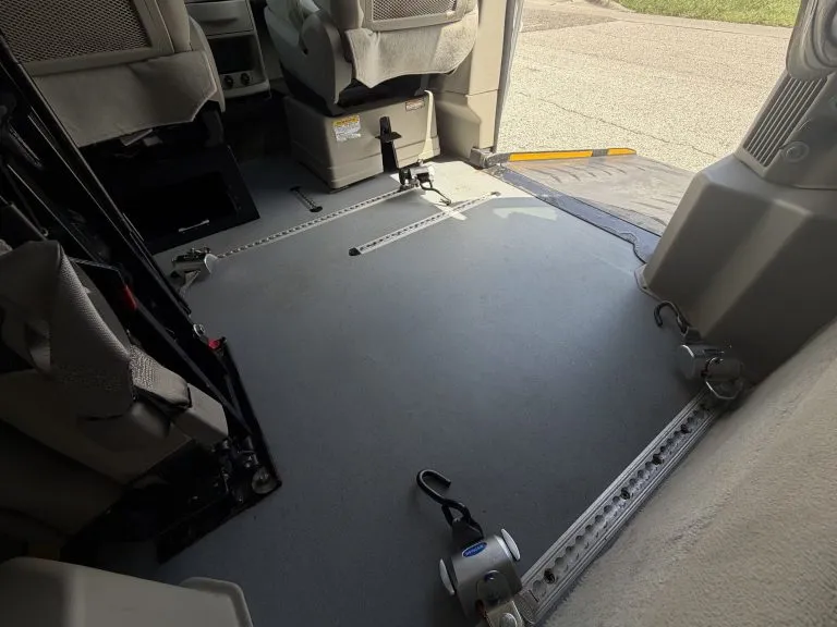 Lowered floor wheelchair bay with L-track securement rails set into the floor