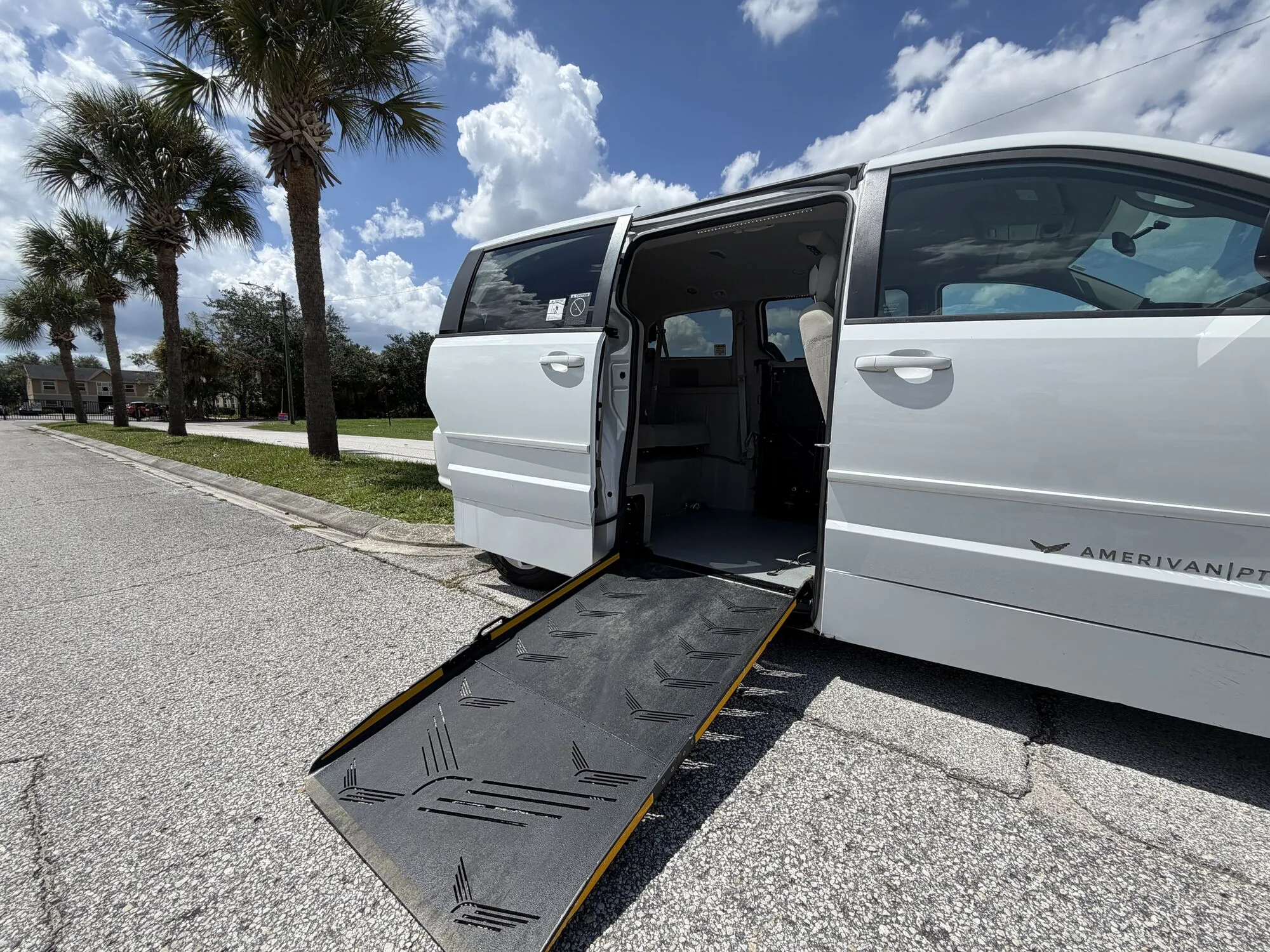 Wheelchair van with the side entry ramp extended to the pavement, AmeriVan conversion badge visible on the rocker panel